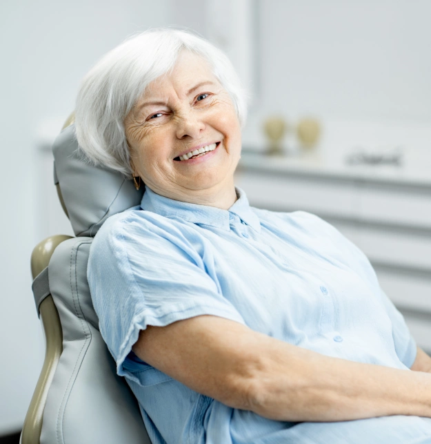 Smiling senior woman with white hair relaxing in a dental chair